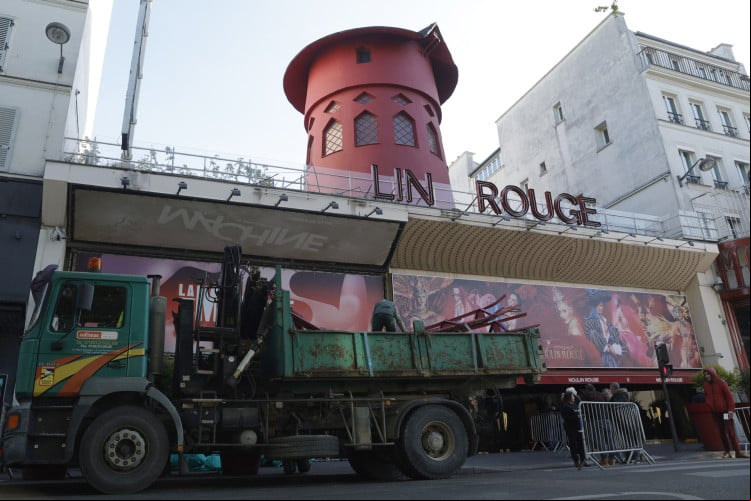 Trabalhadores retiram as pás do Moulin Rouge, que desabaram nesta quinta-feira, 25 Trabalhadores retiram as pás do Moulin Rouge, que desabaram nesta quinta-feira, 25