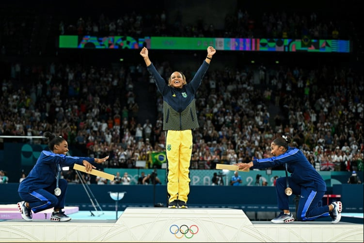 Rebeca Andrade é reverenciada pelas ginastas dos EUA Simone Biles (prata) e Jordan Chiles (bronze) ao receber medalha de ouro nas Olimpíadas 2024, em Paris